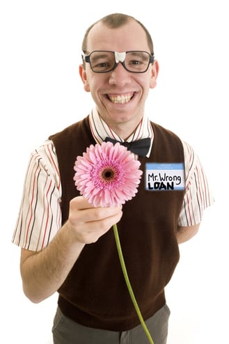 A nerdy guy with a bandaged pair of glasses and a flower is wearing a name tag that says Hello My Name is Mr. Wrong Loan